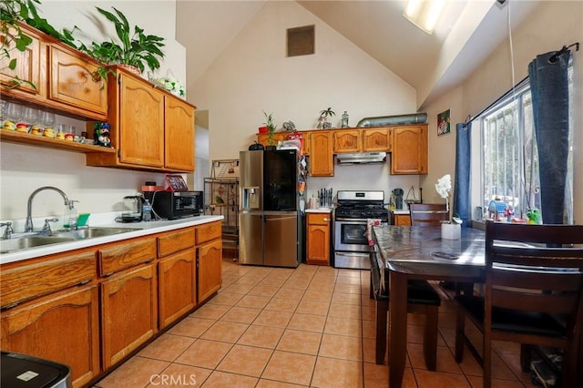 kitchen with light tile patterned floors, appliances with stainless steel finishes, high vaulted ceiling, and sink