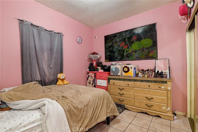 bedroom featuring a textured ceiling and light tile patterned flooring