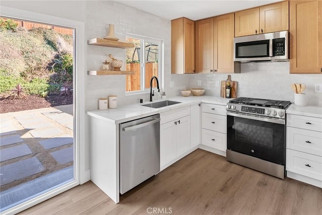 kitchen featuring sink, wood-type flooring, white cabinetry, and appliances with stainless steel finishes