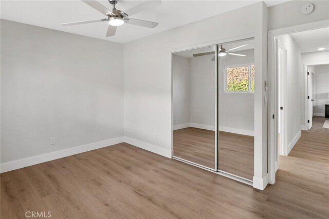 unfurnished bedroom featuring a closet, ceiling fan, and wood-type flooring