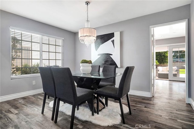 dining room featuring dark hardwood / wood-style floors, a notable chandelier, and a healthy amount of sunlight