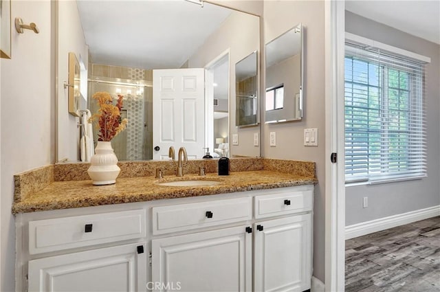 bathroom featuring a shower with shower door, vanity, and hardwood / wood-style flooring