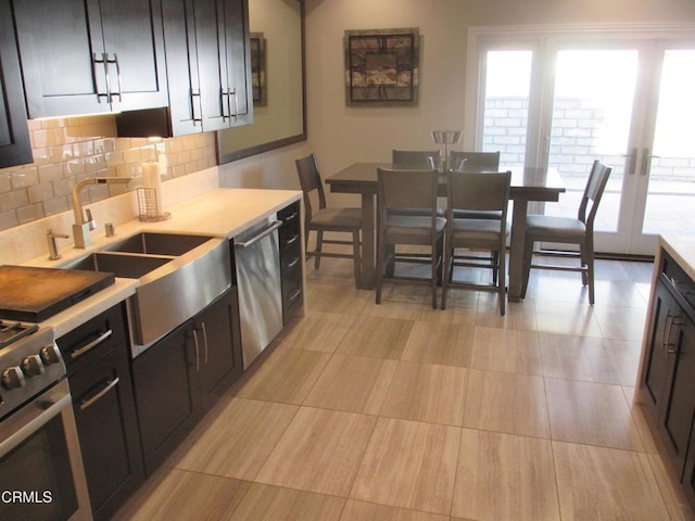 kitchen with tasteful backsplash, appliances with stainless steel finishes, and sink