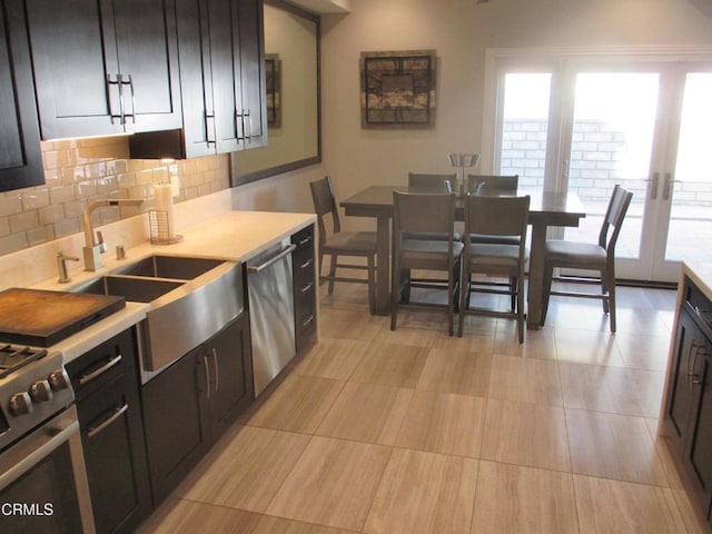 kitchen featuring french doors, stainless steel appliances, backsplash, and sink