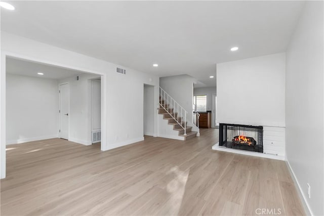 unfurnished living room with light hardwood / wood-style floors and a multi sided fireplace