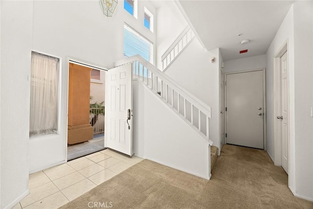 foyer featuring light tile patterned floors and a high ceiling