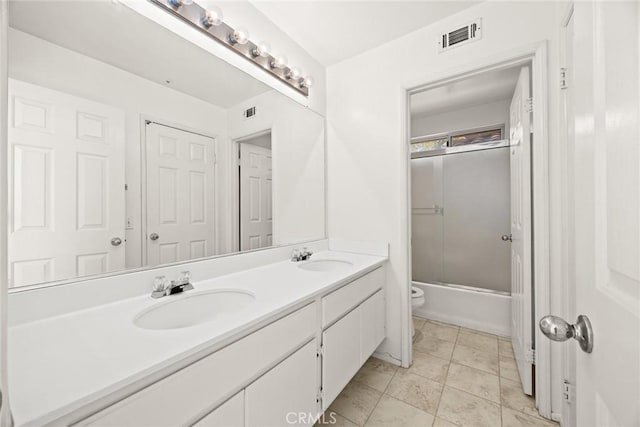 full bathroom with toilet, bath / shower combo with glass door, tile patterned flooring, and vanity