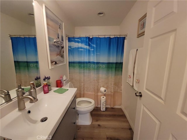 bathroom featuring toilet, vanity, curtained shower, and hardwood / wood-style flooring