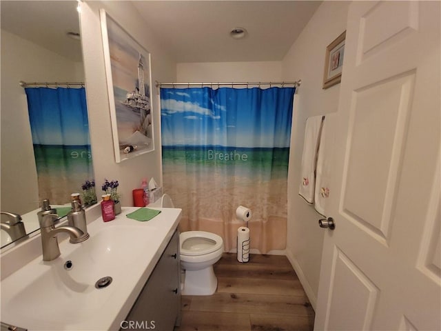 bathroom featuring toilet, vanity, wood-type flooring, and walk in shower