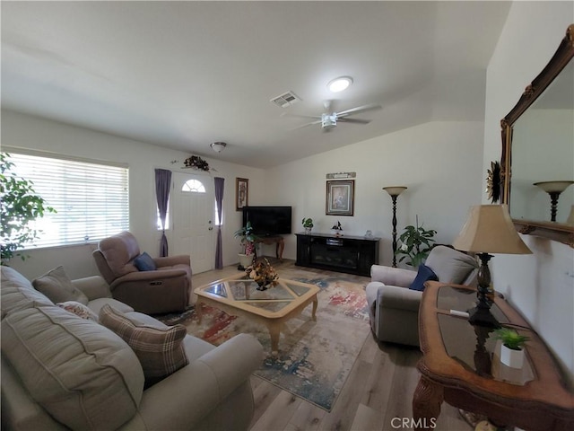 living room featuring ceiling fan, vaulted ceiling, and light wood-type flooring