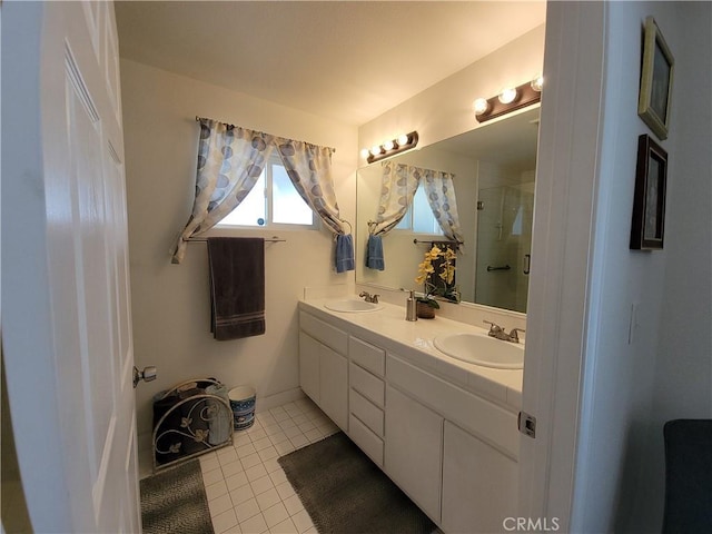 bathroom with a shower with door, vanity, and tile patterned flooring