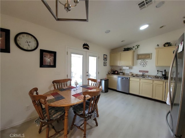 dining room featuring french doors, vaulted ceiling, sink, and light hardwood / wood-style flooring