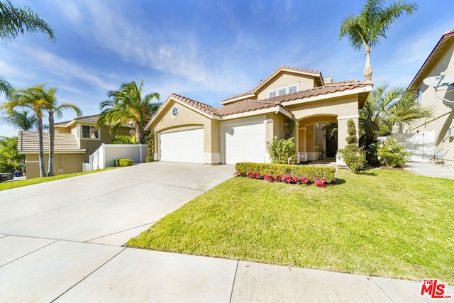 mediterranean / spanish house with a garage and a front yard