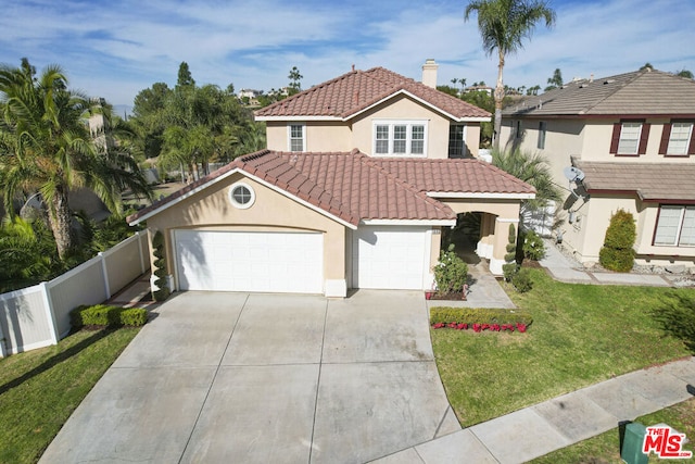 mediterranean / spanish house with a garage and a front yard