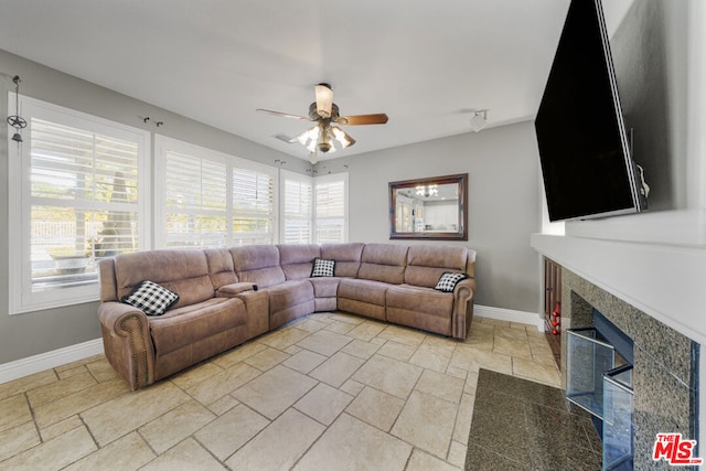 living room featuring ceiling fan and a fireplace