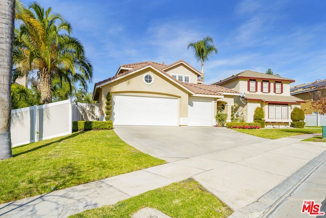 mediterranean / spanish-style home with a garage and a front lawn