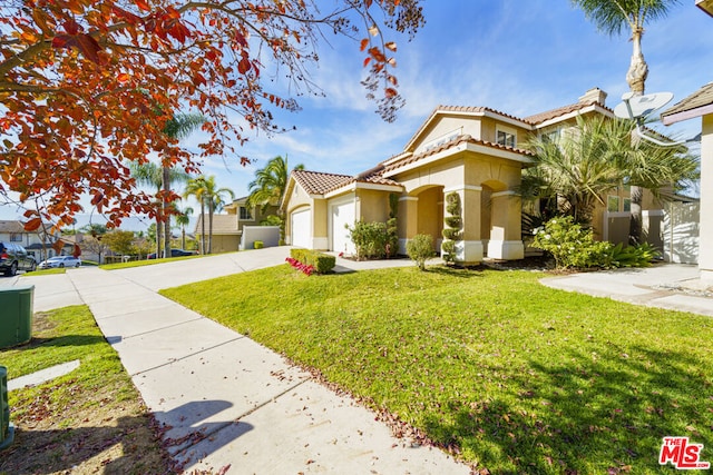 mediterranean / spanish-style house featuring a front lawn and a garage