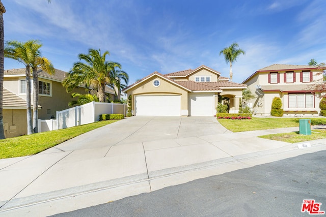 mediterranean / spanish-style home featuring a front yard and a garage