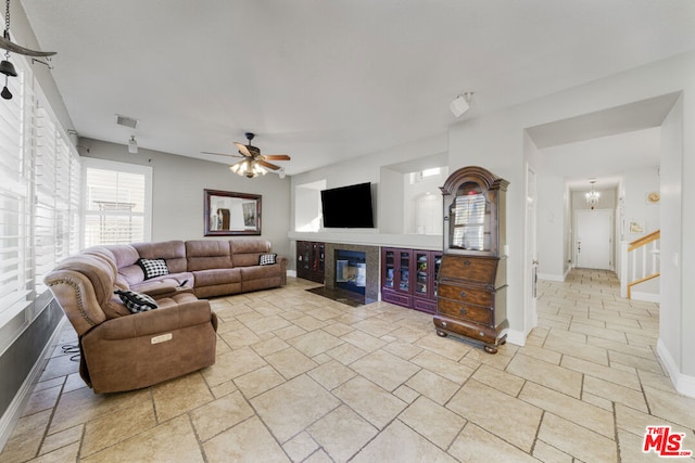 living room featuring ceiling fan with notable chandelier