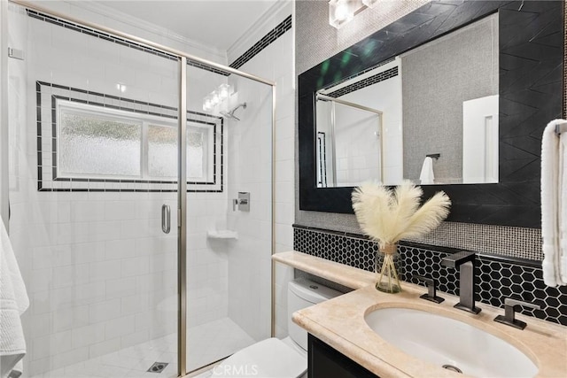 bathroom featuring a shower with door, vanity, decorative backsplash, toilet, and ornamental molding