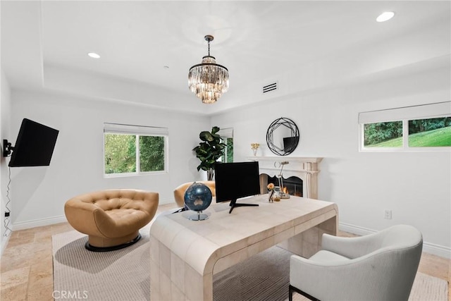 home office with a raised ceiling and a notable chandelier