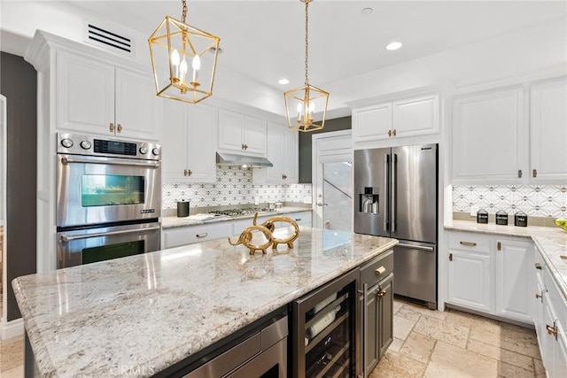 kitchen featuring stainless steel appliances, decorative light fixtures, wine cooler, light stone countertops, and white cabinets