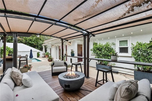 wooden terrace with an outdoor living space with a fire pit