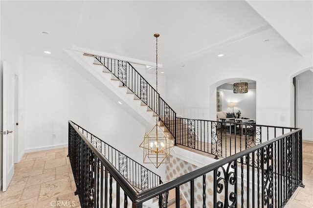 staircase with a notable chandelier