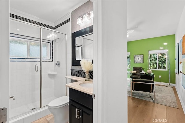 bathroom featuring toilet, vanity, walk in shower, and hardwood / wood-style flooring