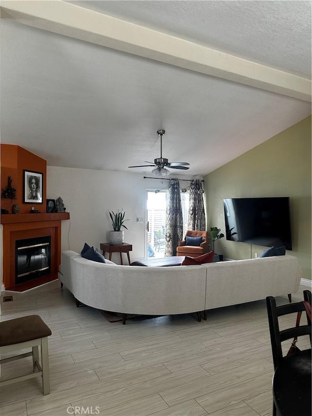 living room featuring a textured ceiling, lofted ceiling with beams, and ceiling fan