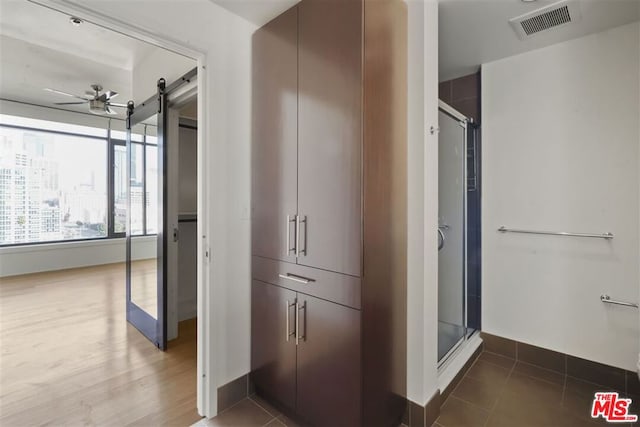 bathroom featuring ceiling fan, tile patterned flooring, and walk in shower