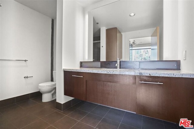 bathroom with ceiling fan, toilet, vanity, and tile patterned flooring