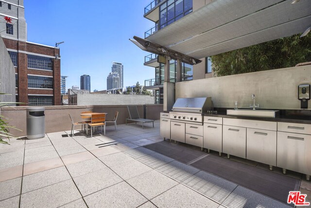 view of patio with exterior kitchen, sink, and a grill