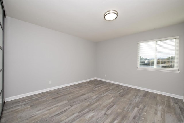 unfurnished room with hardwood / wood-style flooring