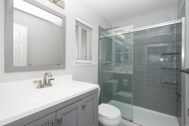 bathroom featuring toilet, vanity, and an enclosed shower