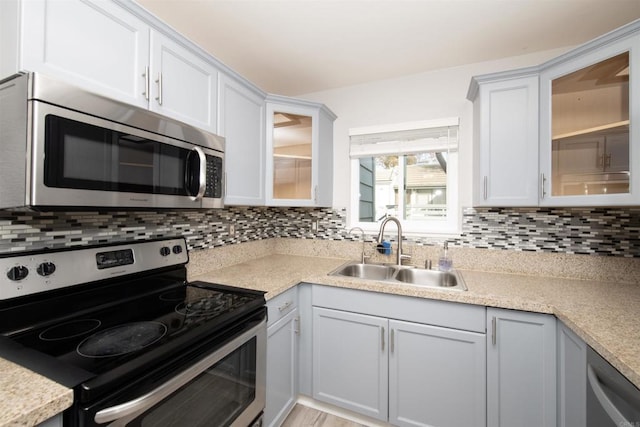 kitchen featuring sink, backsplash, white cabinets, and stainless steel appliances