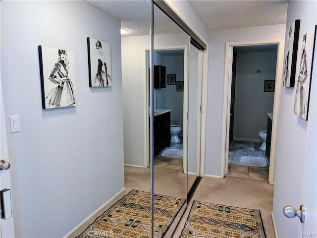 hall featuring carpet floors and a textured ceiling