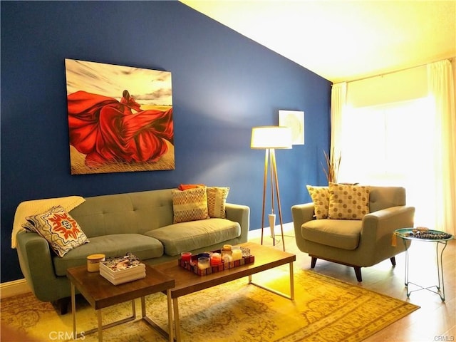 sitting room with lofted ceiling and wood-type flooring