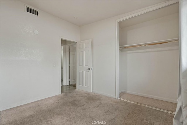 unfurnished bedroom featuring light colored carpet and a closet