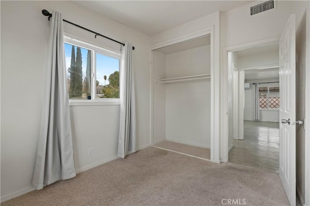 unfurnished bedroom featuring light colored carpet and a closet