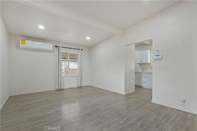 unfurnished room featuring beamed ceiling and a wall mounted air conditioner