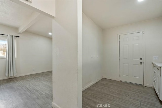 foyer entrance with light wood-type flooring and beamed ceiling