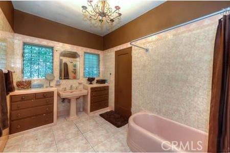 bathroom with a chandelier, tile patterned floors, and shower / bathtub combination with curtain