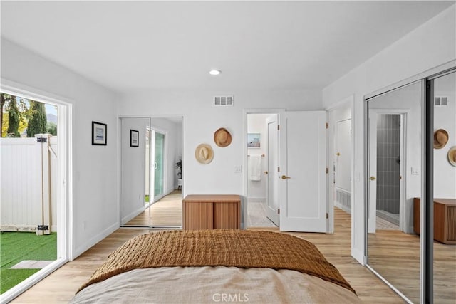 unfurnished bedroom with ensuite bathroom, a closet, access to outside, and light wood-type flooring