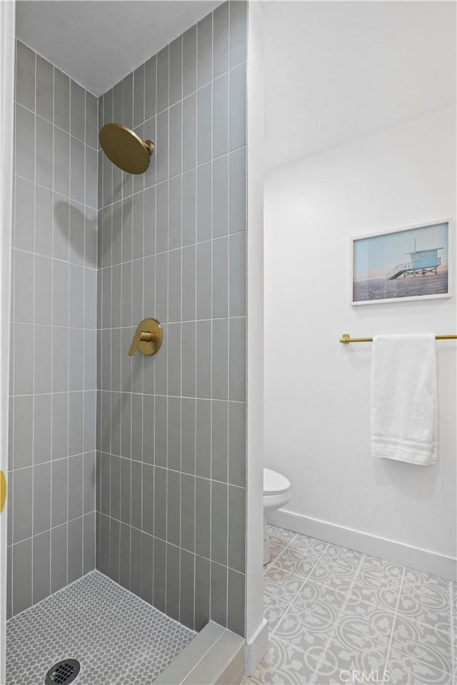 bathroom with tile patterned floors, toilet, and a tile shower