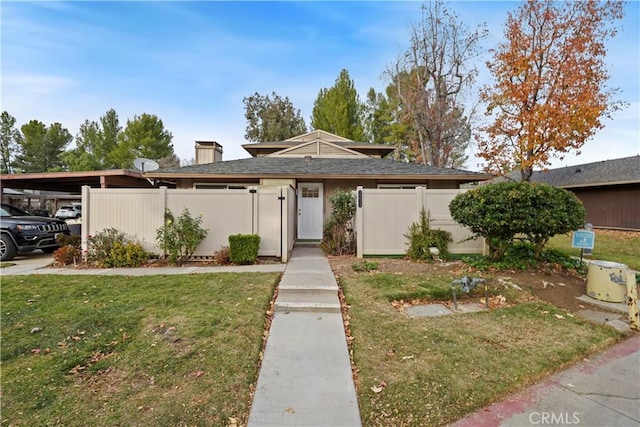 view of front of house with a front lawn and a carport