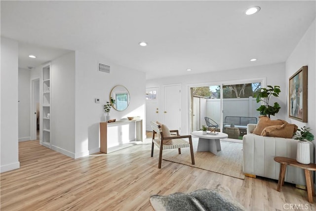 living room with light hardwood / wood-style floors and built in features