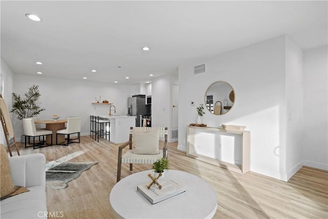 living room featuring sink and light wood-type flooring