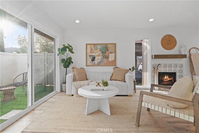 living room featuring light hardwood / wood-style floors and a tiled fireplace