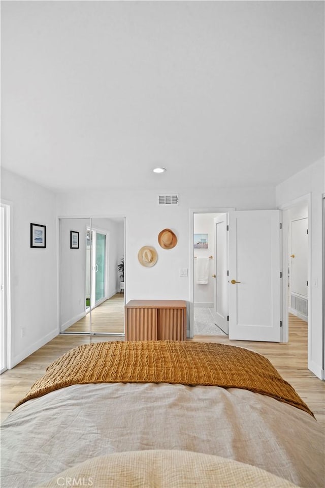 unfurnished bedroom with ensuite bath and light hardwood / wood-style floors